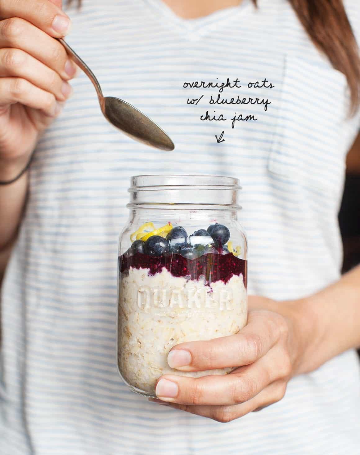 Overnight Oats with Blueberry Chia Jam in a jar held by hands