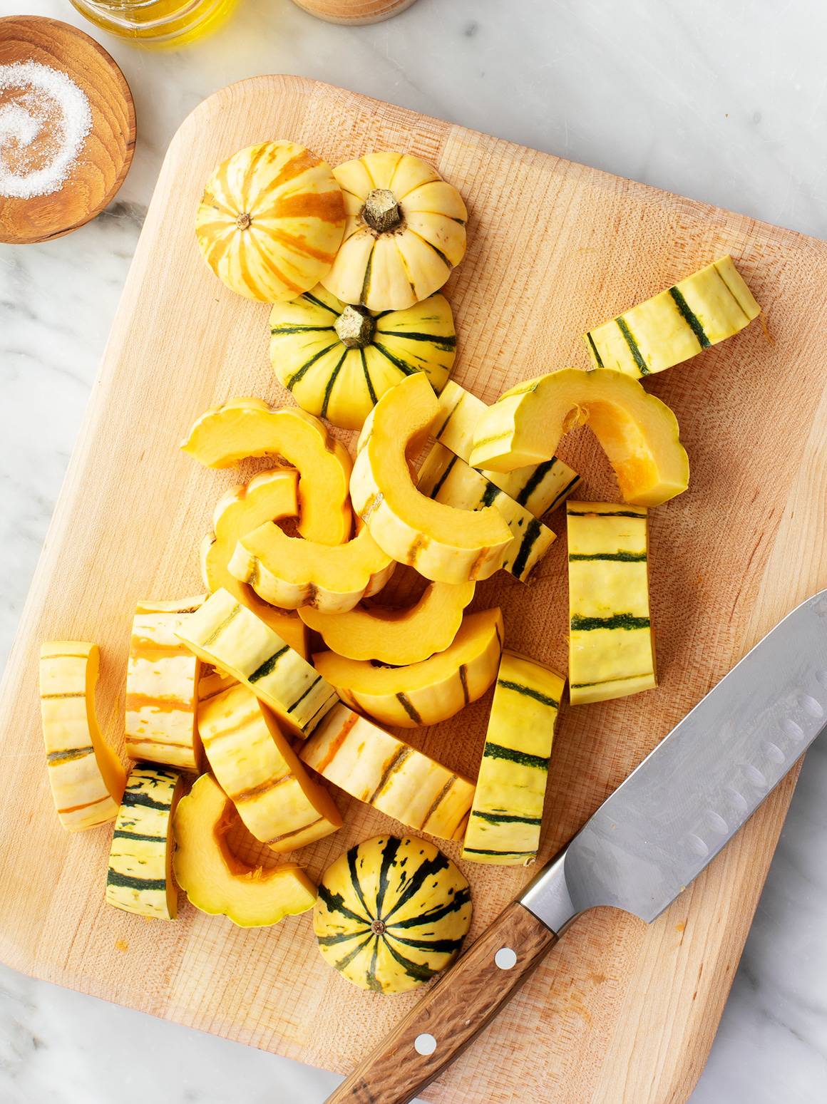 Chopped delicata squash on a cutting board