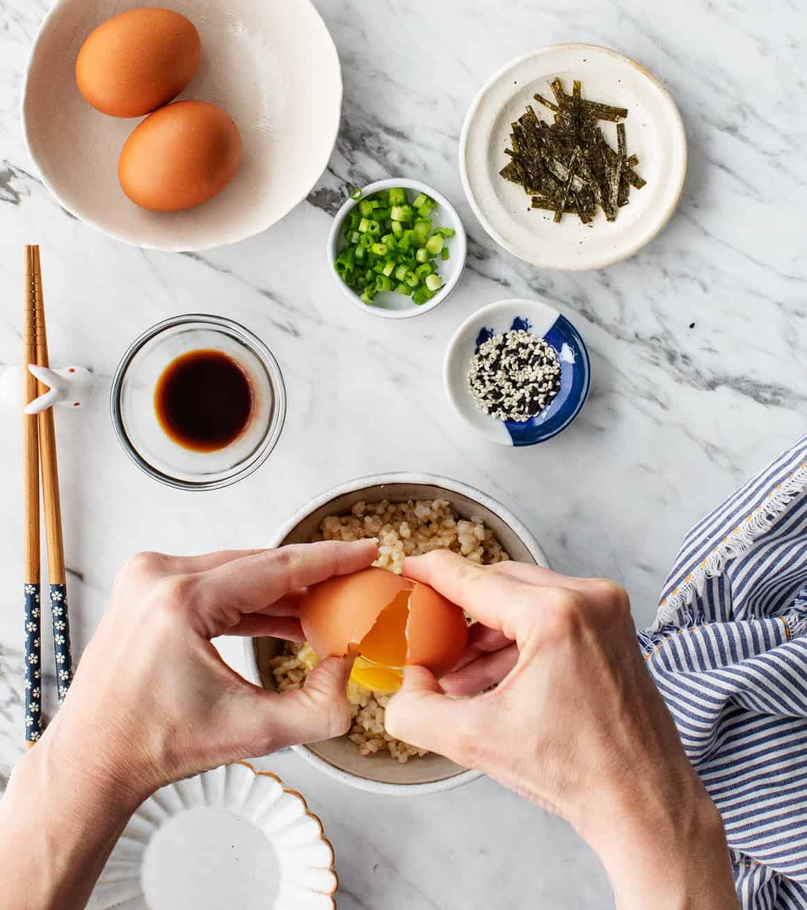 Cracking an egg over brown rice