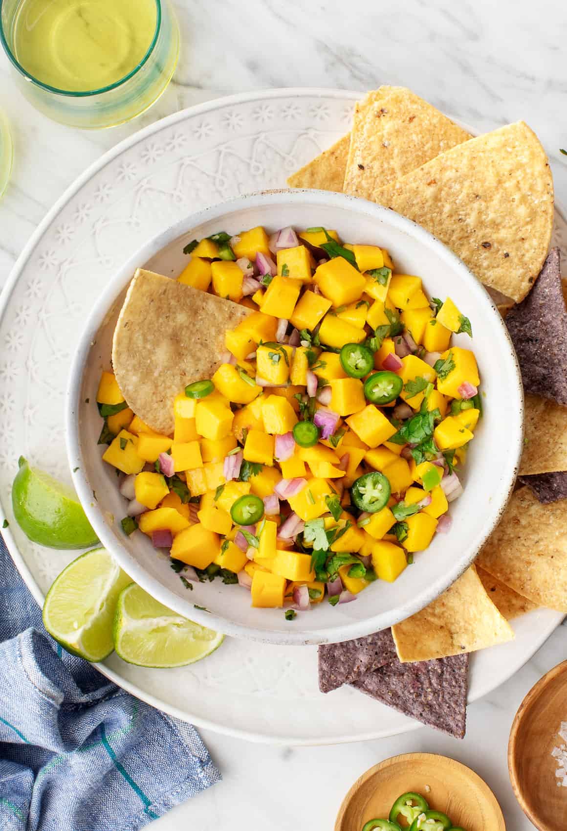 Bowl of mango salsa with tortilla chips and lime wedges