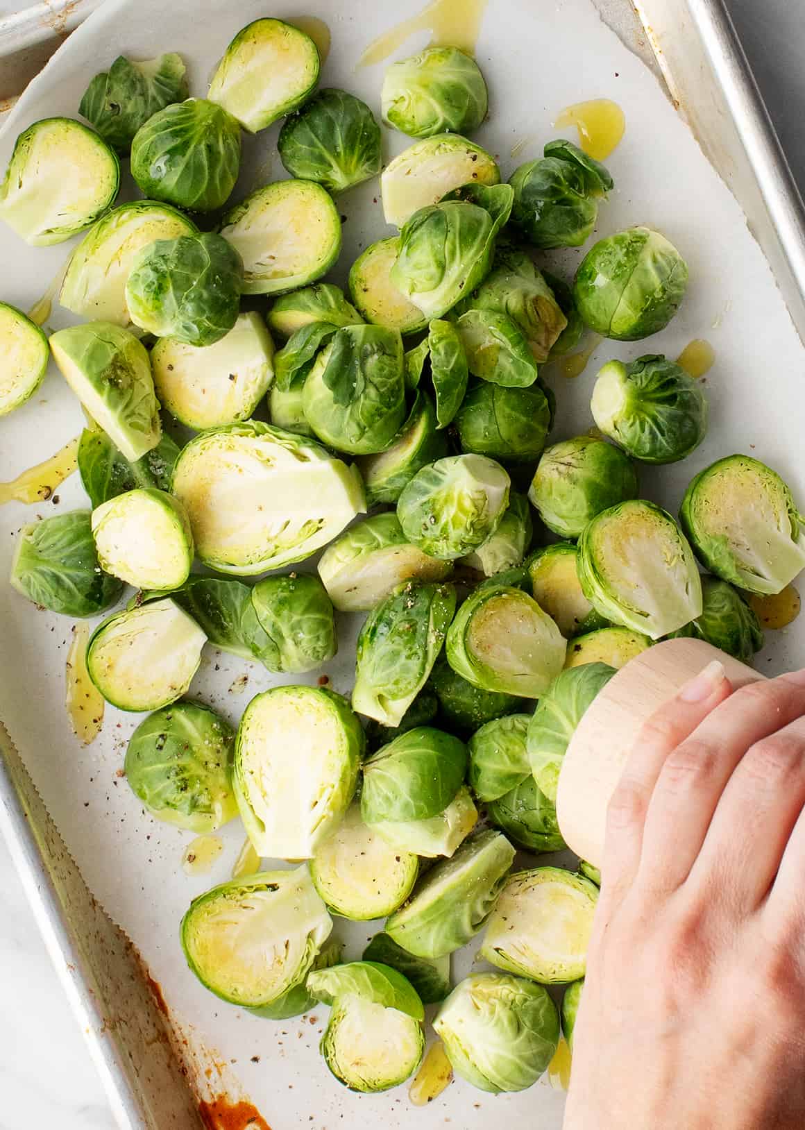 Brussel sprouts on a baking sheet with olive oil