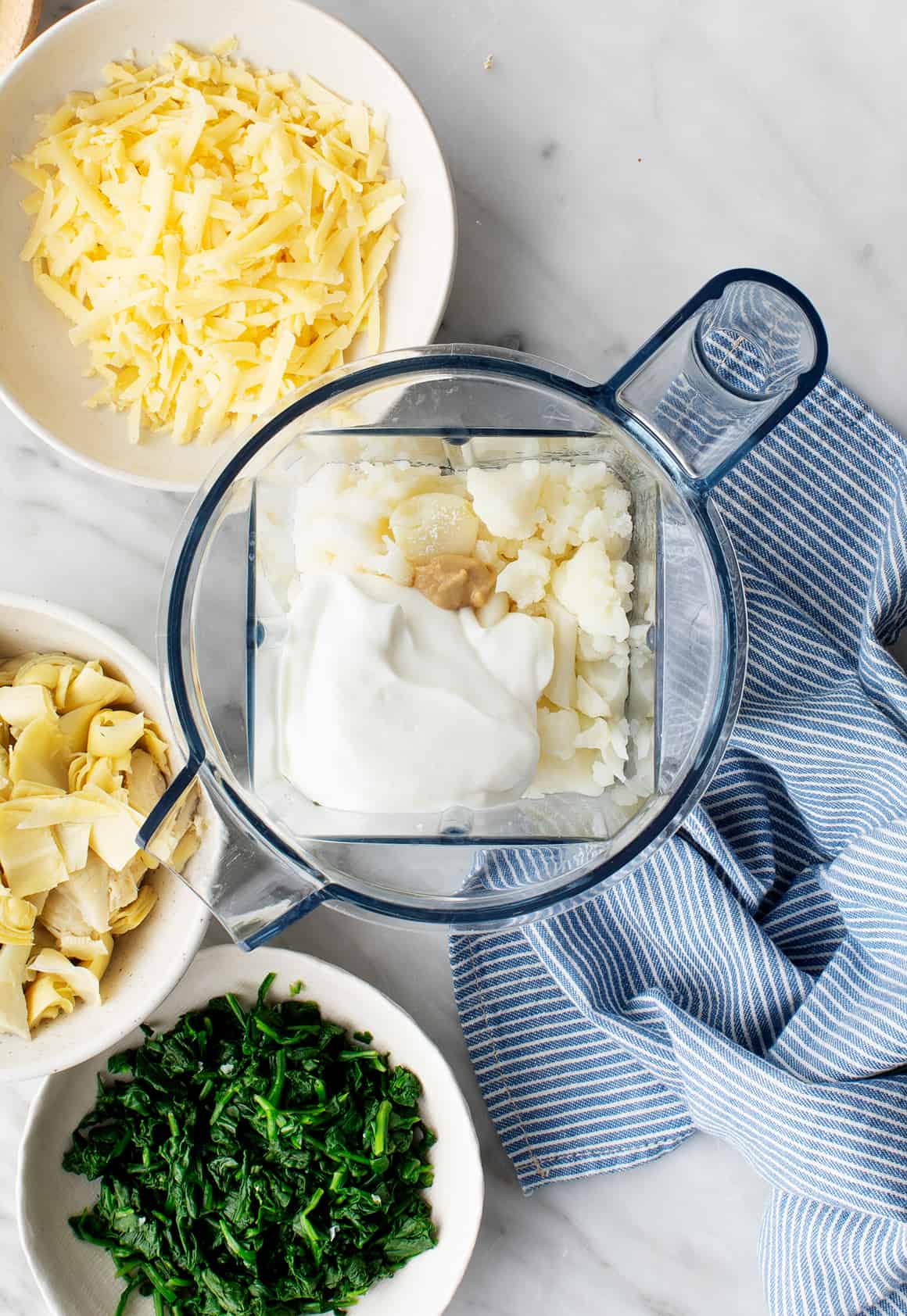 Spinach artichoke dip ingredients in a blender