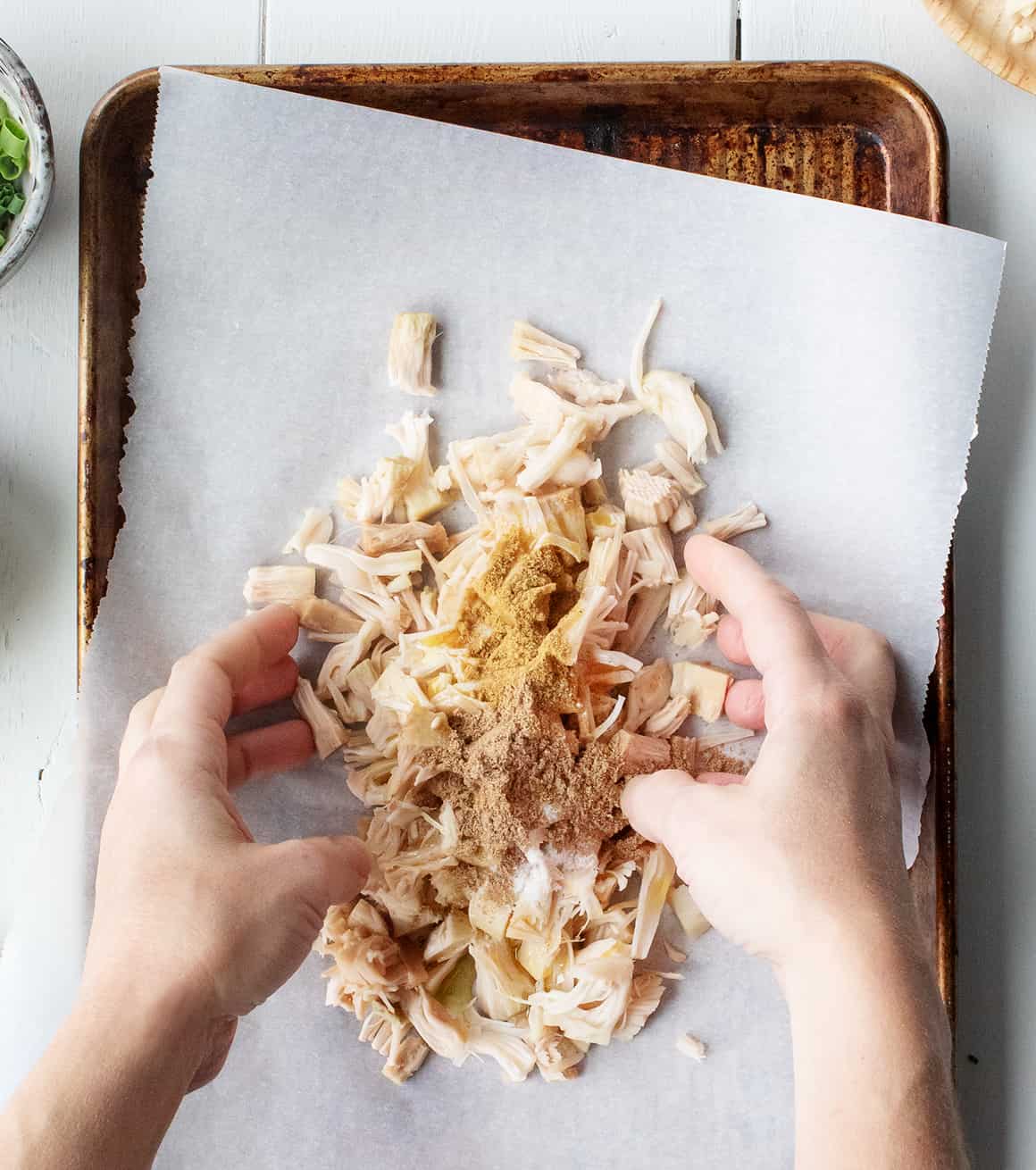 Shredded jackfruit and spices on a baking sheet