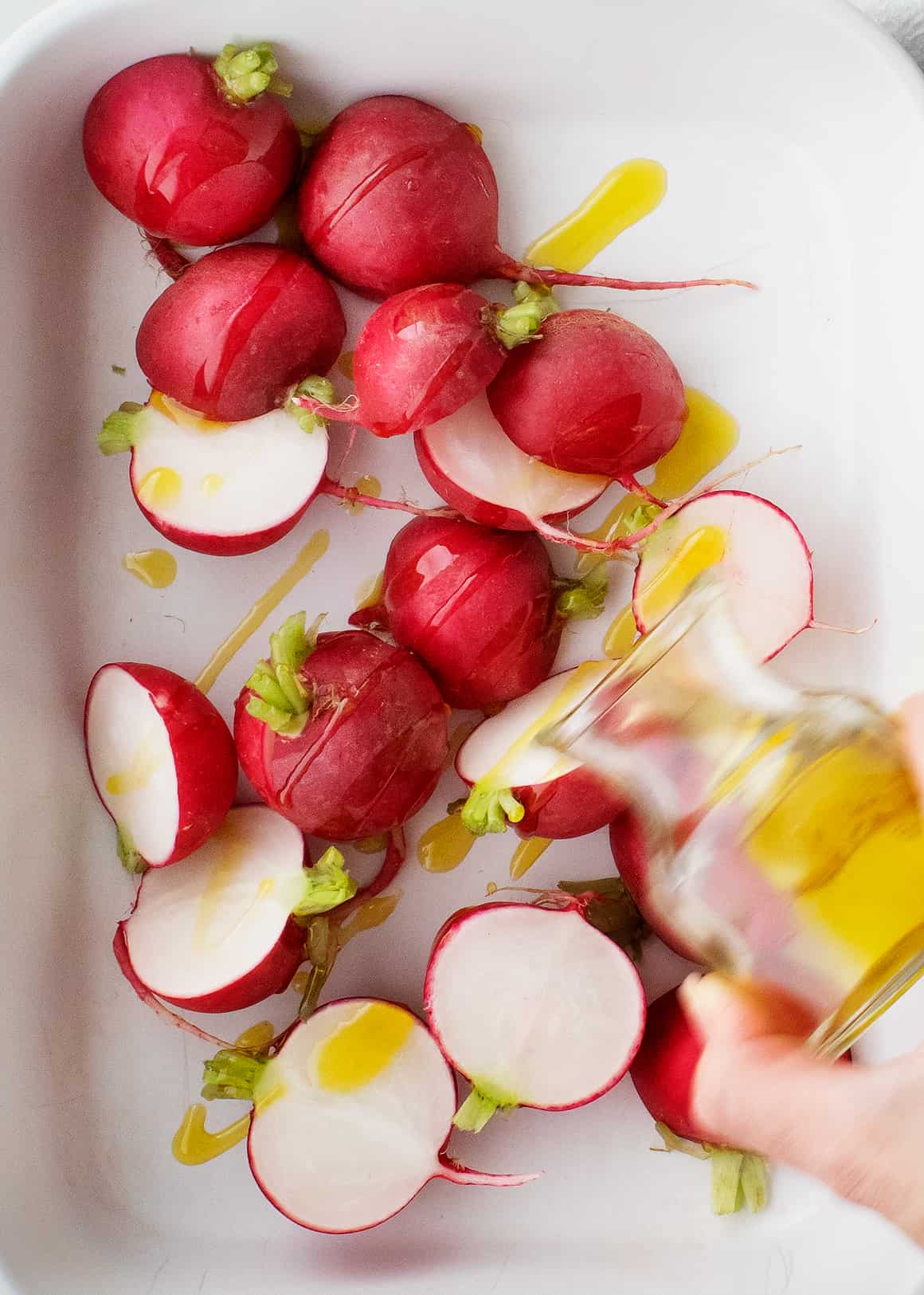 Radishes in a baking dish with olive oil