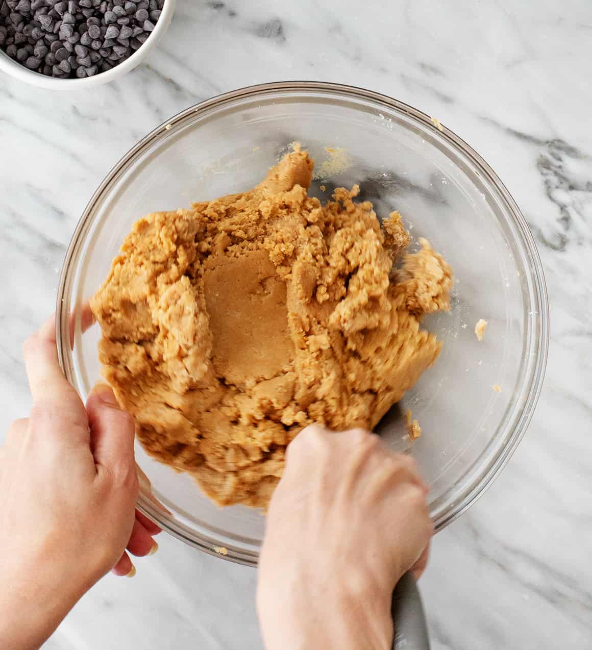 Hands mixing vegan edible cookie dough