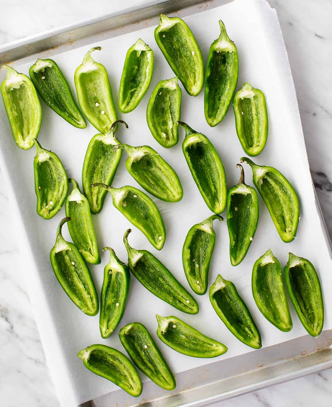 Sliced jalapenos on a baking sheet