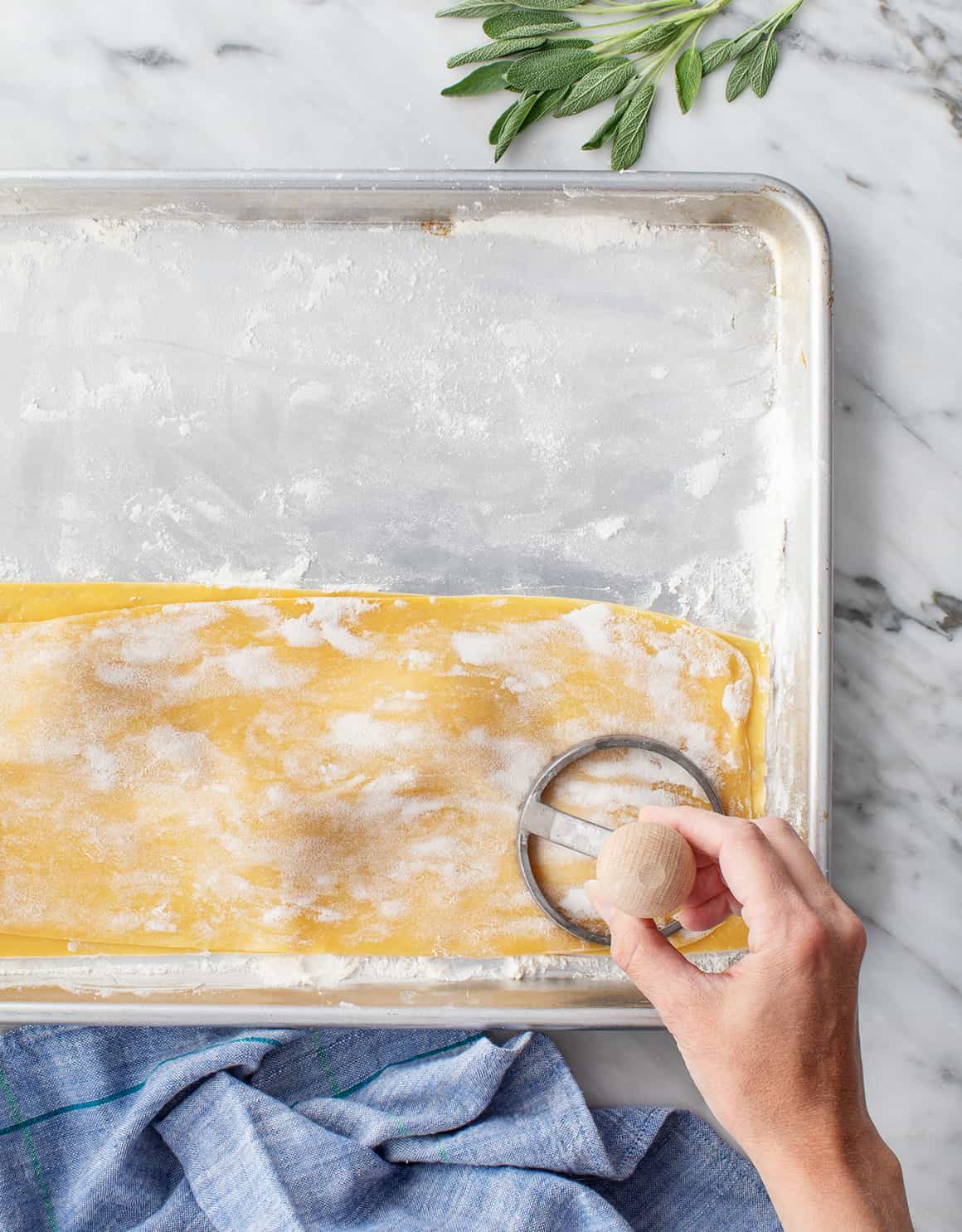 Hand cutting out homemade ravioli with a stamp