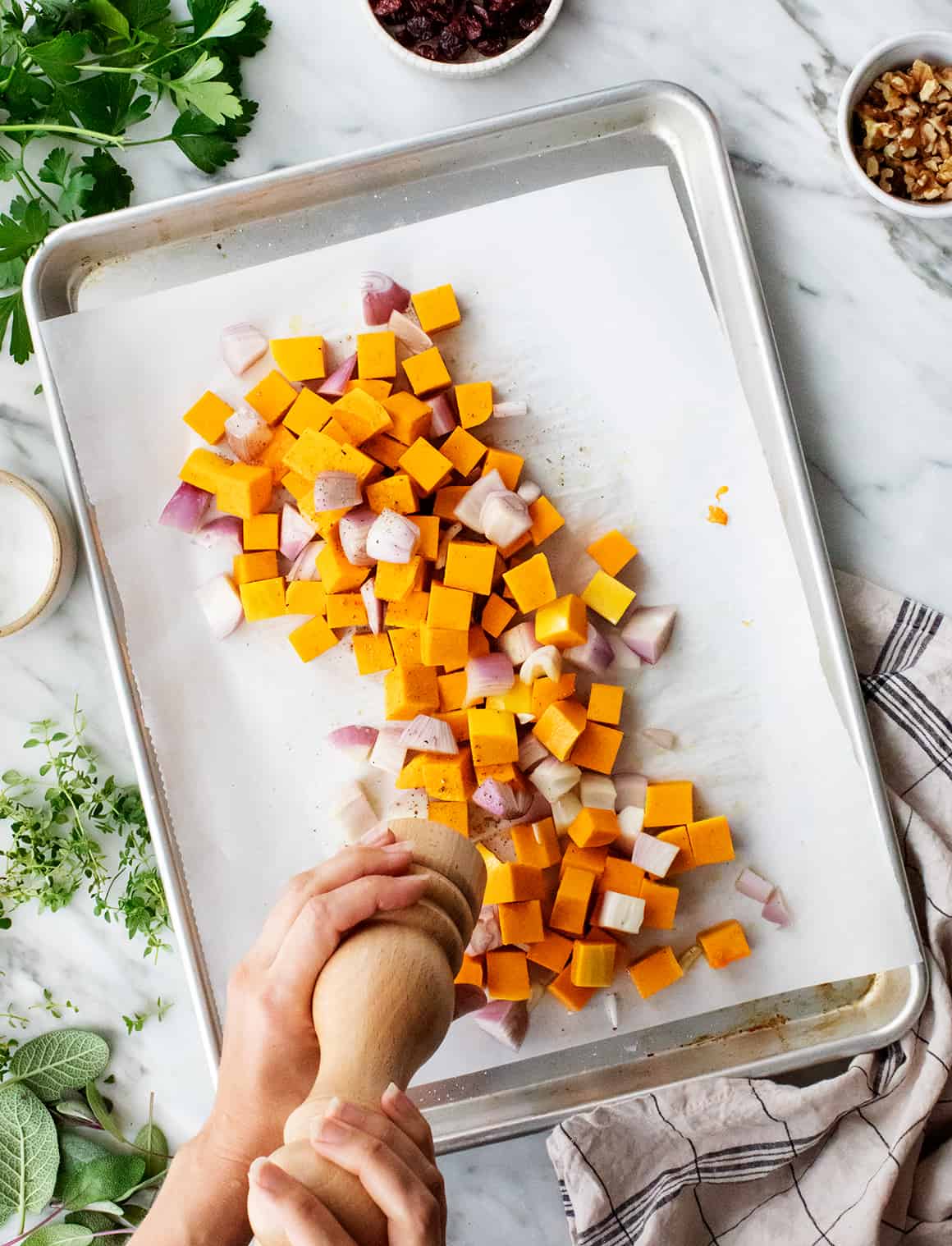 Diced butternut squash and shallots on a baking sheet