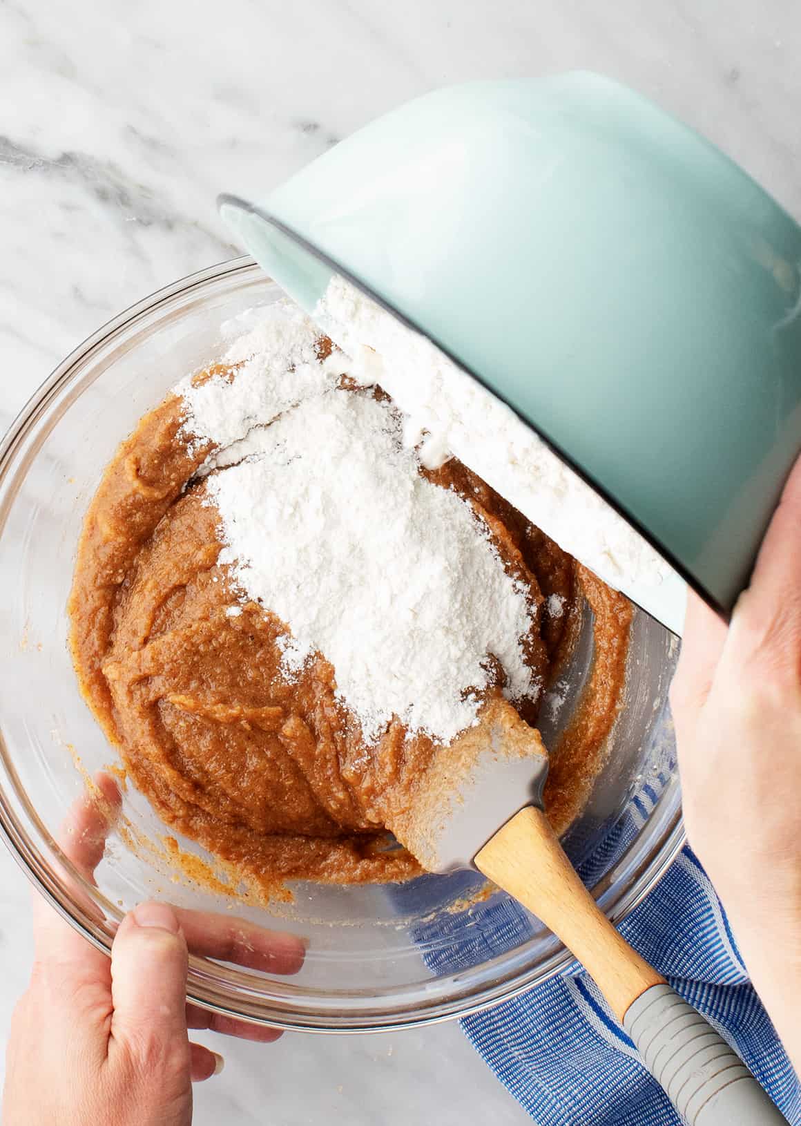 Pouring dry ingredients into wet ingredients