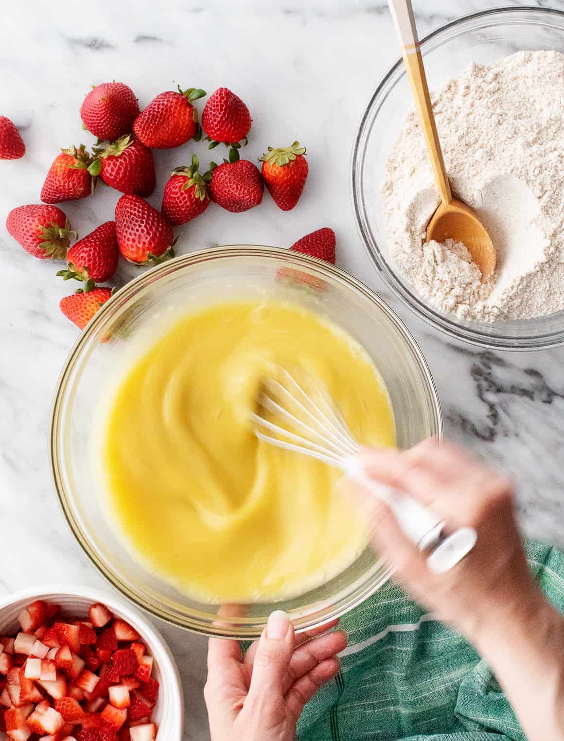 Hand whisking wet ingredients in mixing bowl