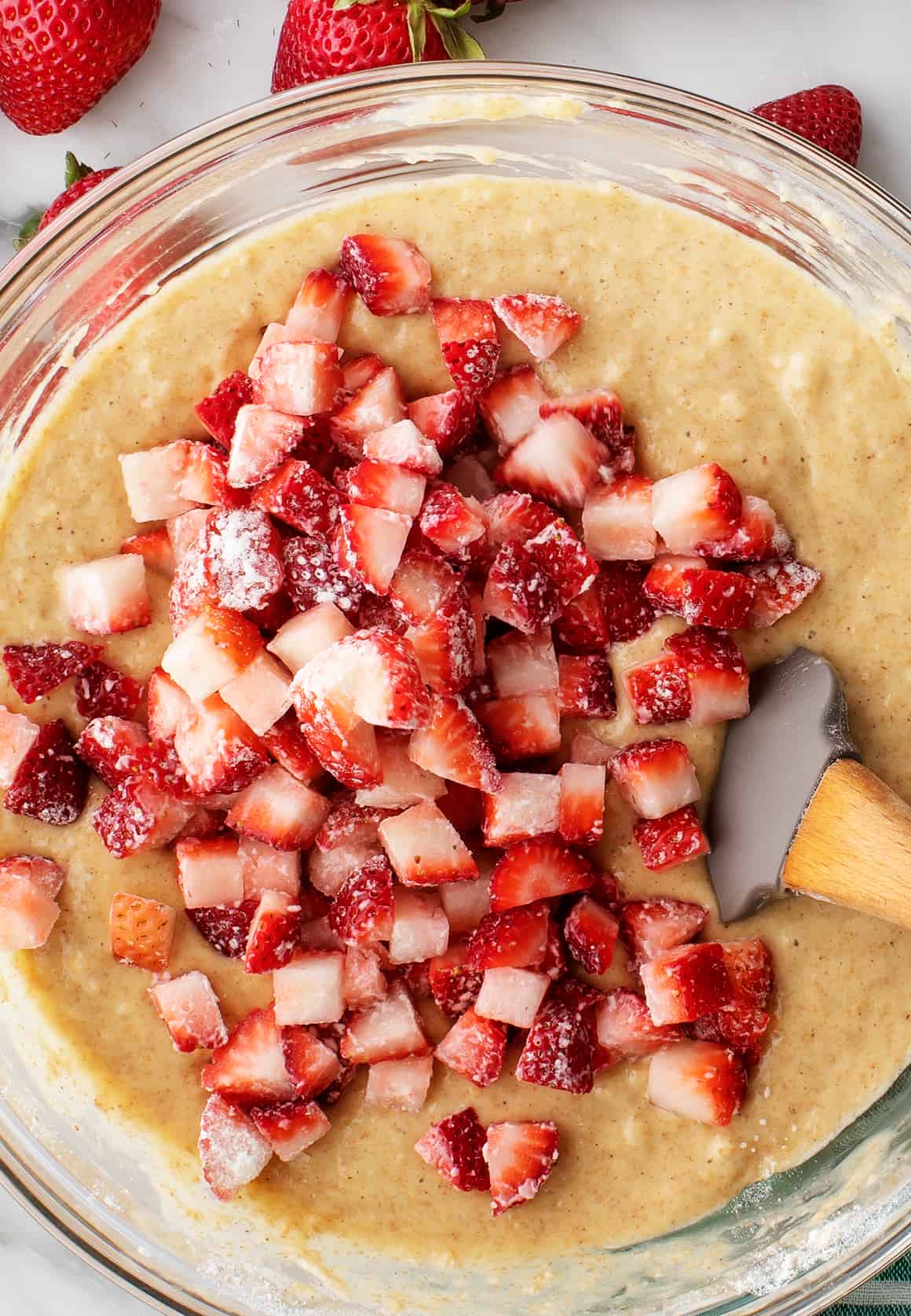 Folding diced strawberries into muffin batter