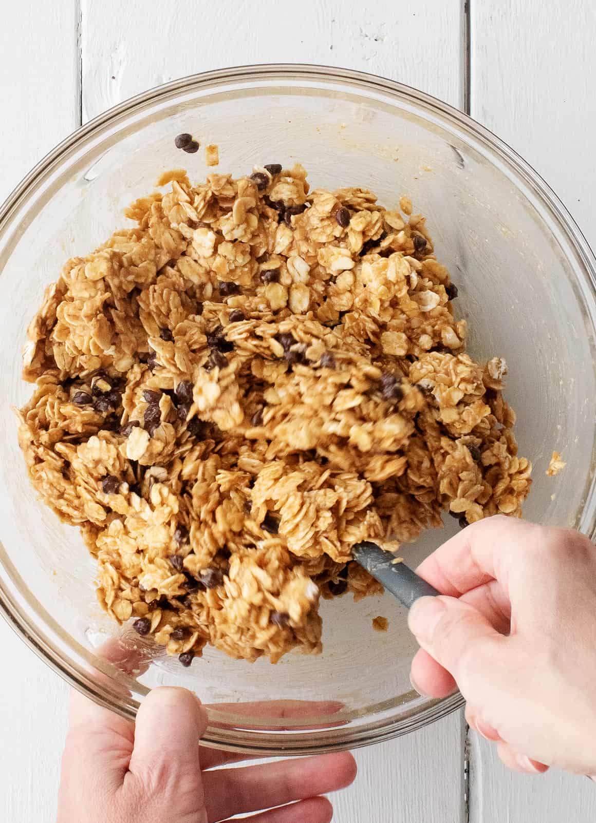 Folding no bake oatmeal cookie dough in a mixing bowl
