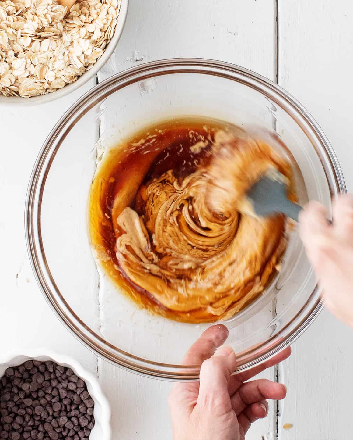 Stirring peanut butter and maple syrup in a large bowl