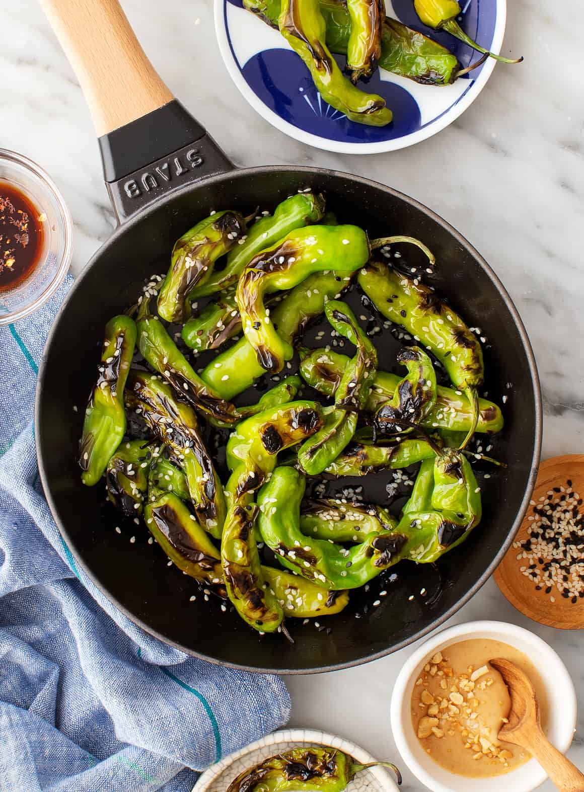 Blistered shishito peppers in a skillet - easy summer appetizers