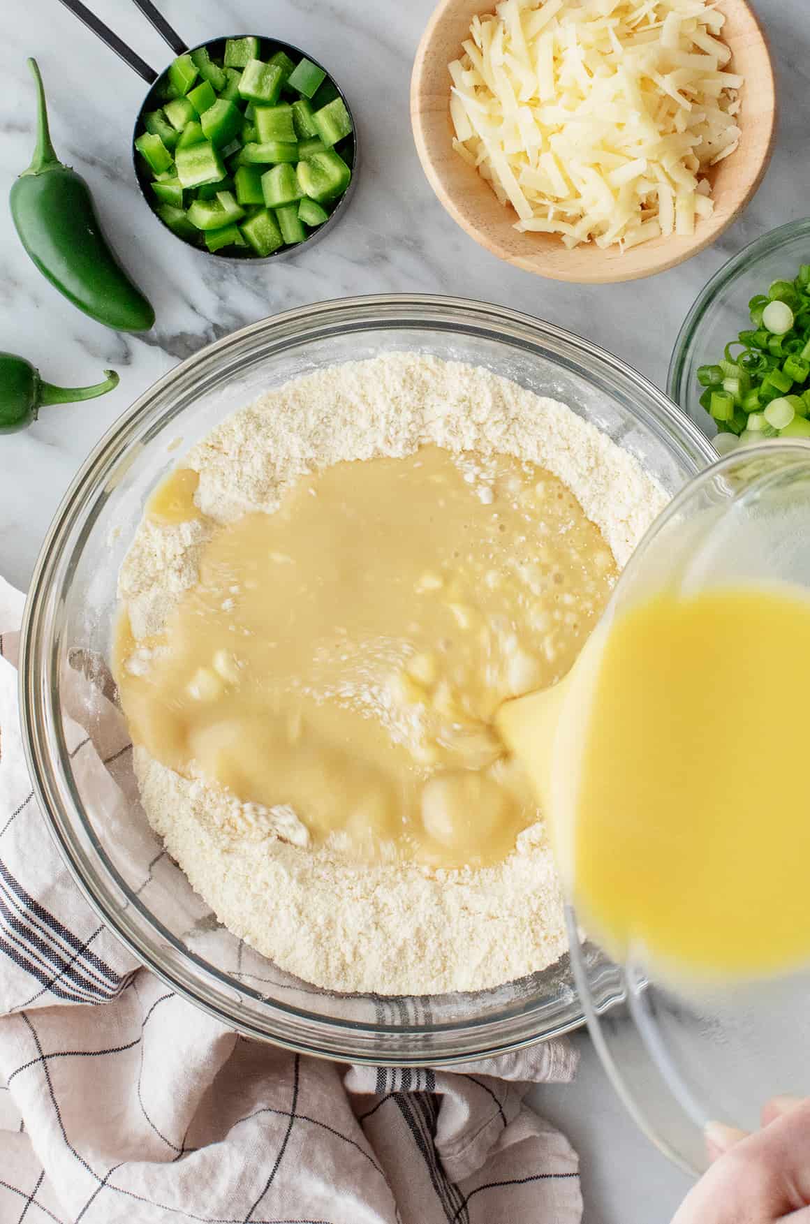 Pouring wet ingredients into bowl of dry ingredients