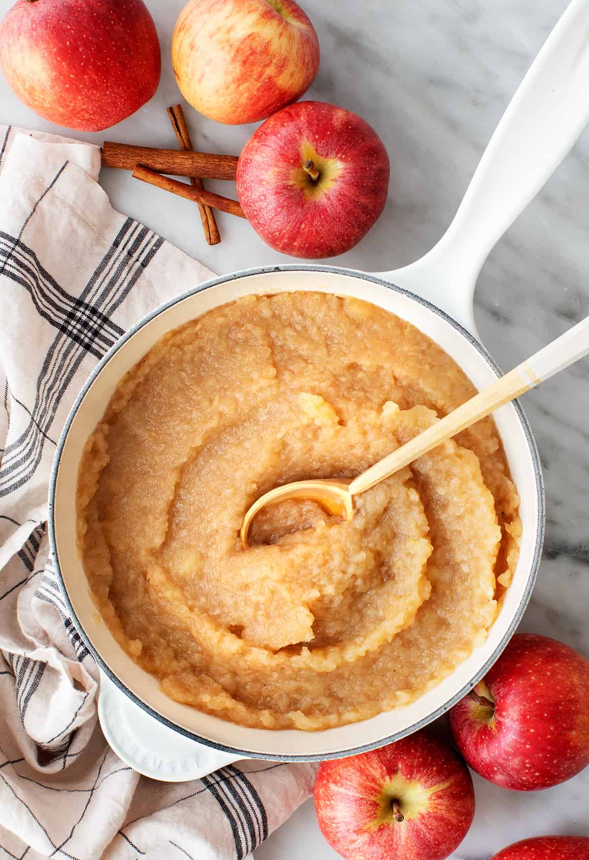 Homemade applesauce in saucepan with wooden spoon