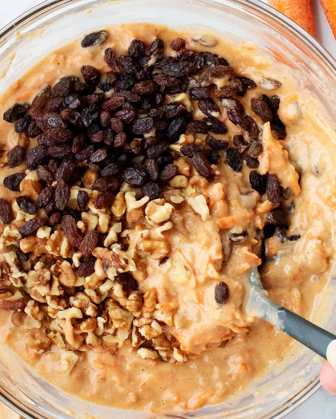 folding raisins and walnuts into carrot muffin batter