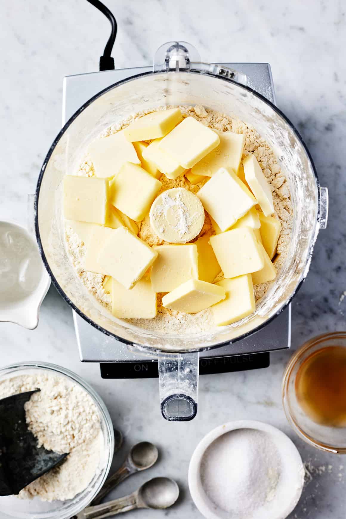 Pats of butter on top of flour in food processor