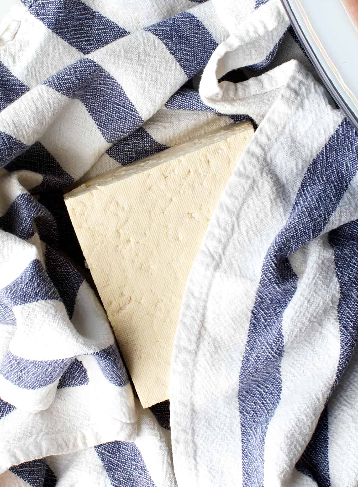 Block of tofu wrapped in kitchen towel