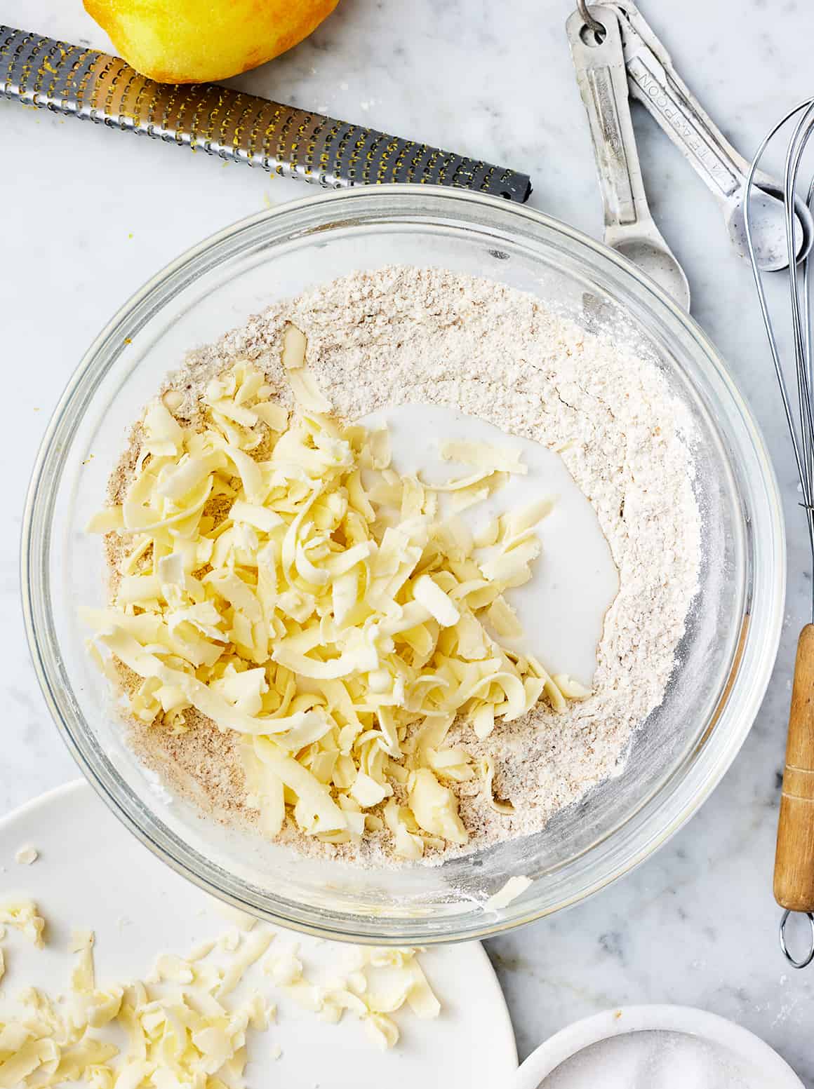 Grated butter, coconut milk, and flour in a mixing bowl