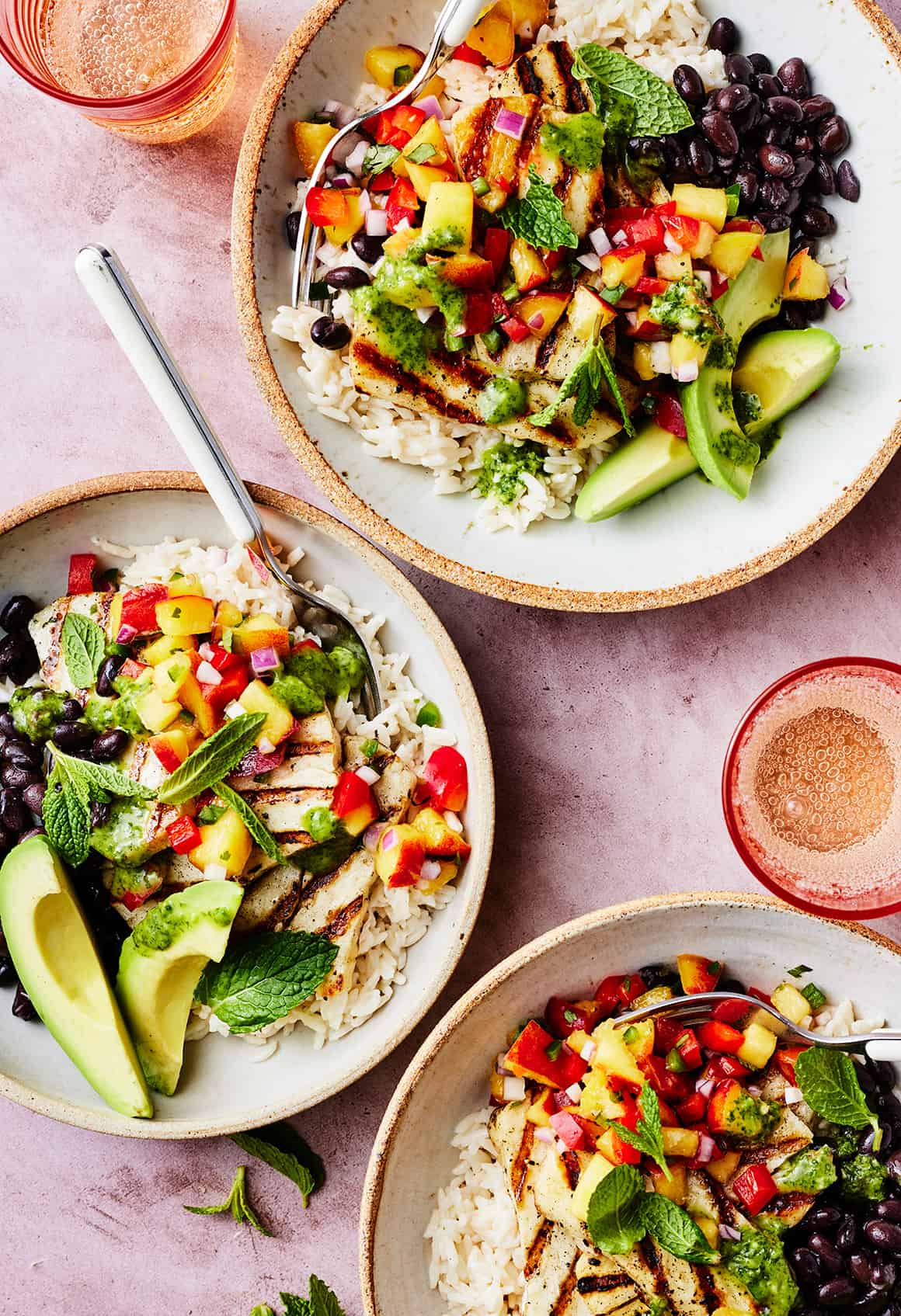 Coconut rice bowls with black beans, halloumi, avocado, peach salsa, and cilantro lime dressing