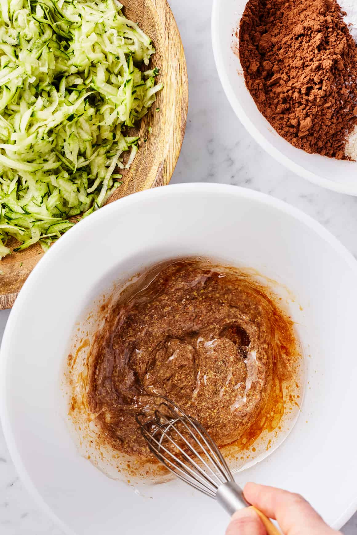 Hand whisking wet ingredients in mixing bowl