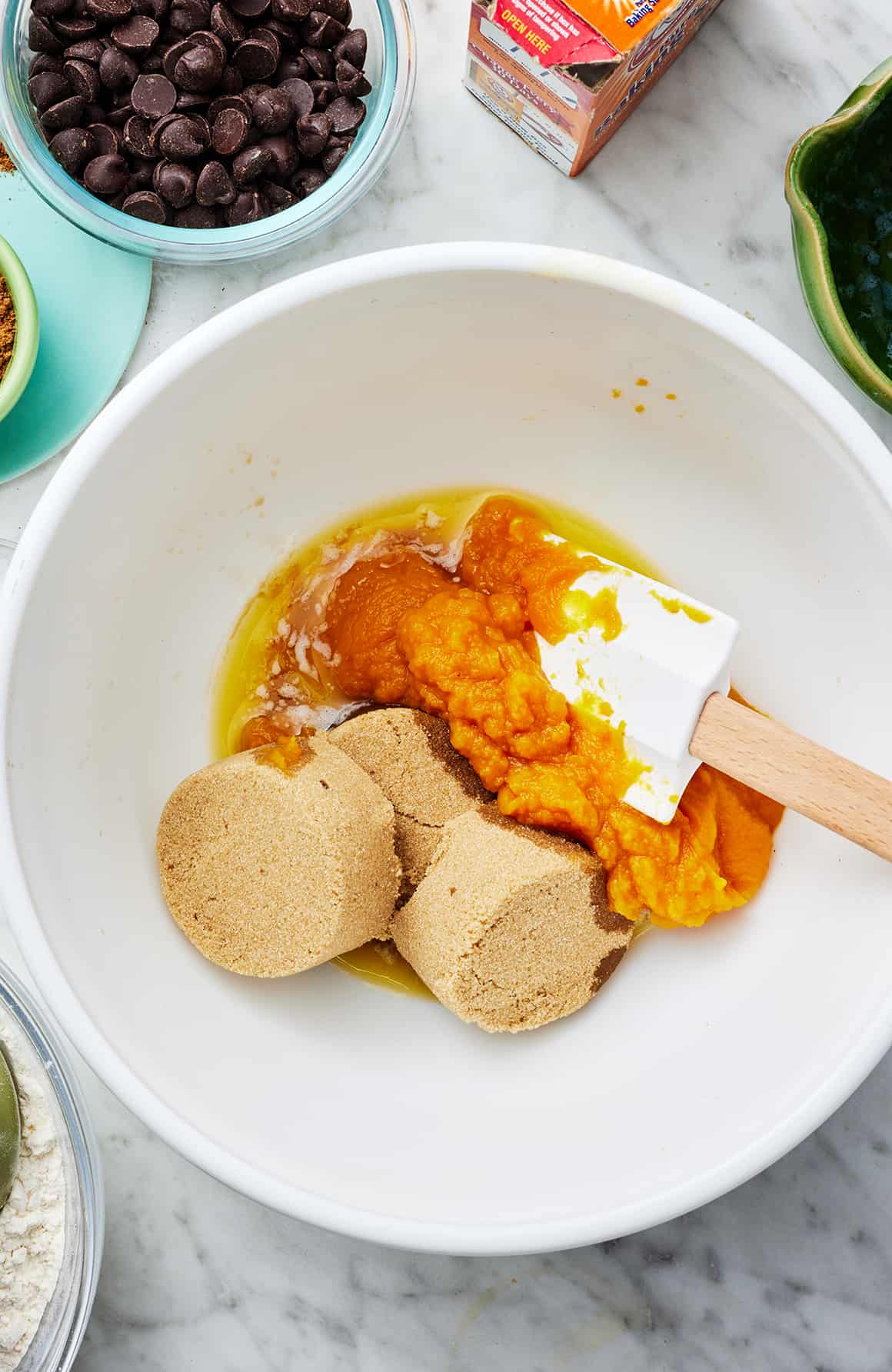 Wet ingredients in a mixing bowl with rubber spatula