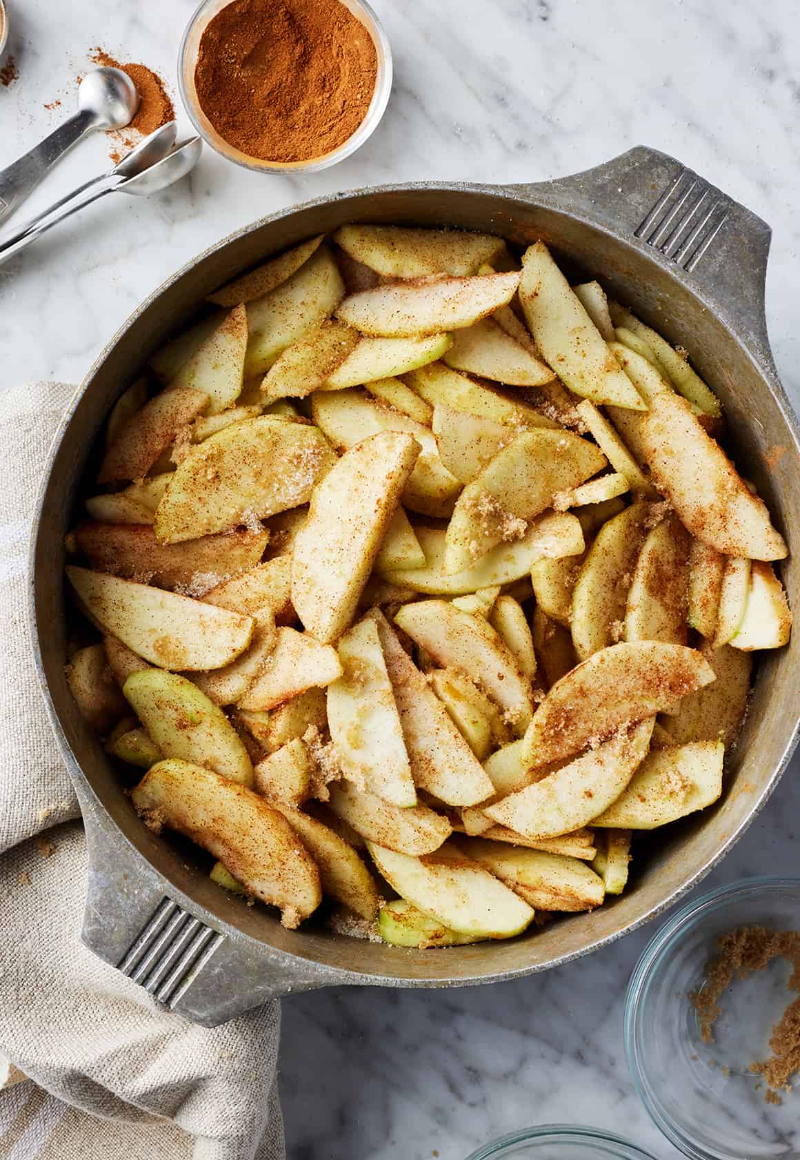 Sliced apples coated with cinnamon and sugar in large pot