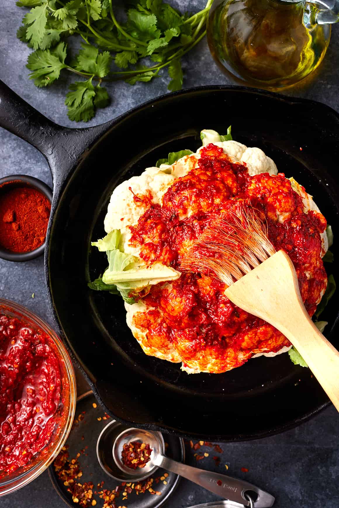 Brushing sauce over head of cauliflower