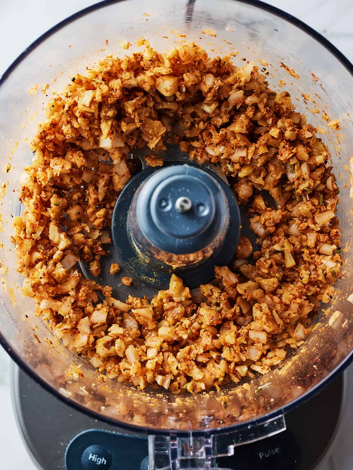 Finely chopped onion and spice mixture in a food processor