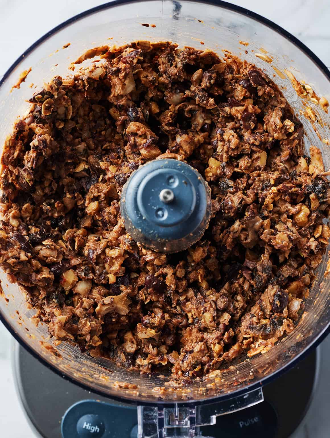 Finely chopped vegan meatballs ingredients in a food processor