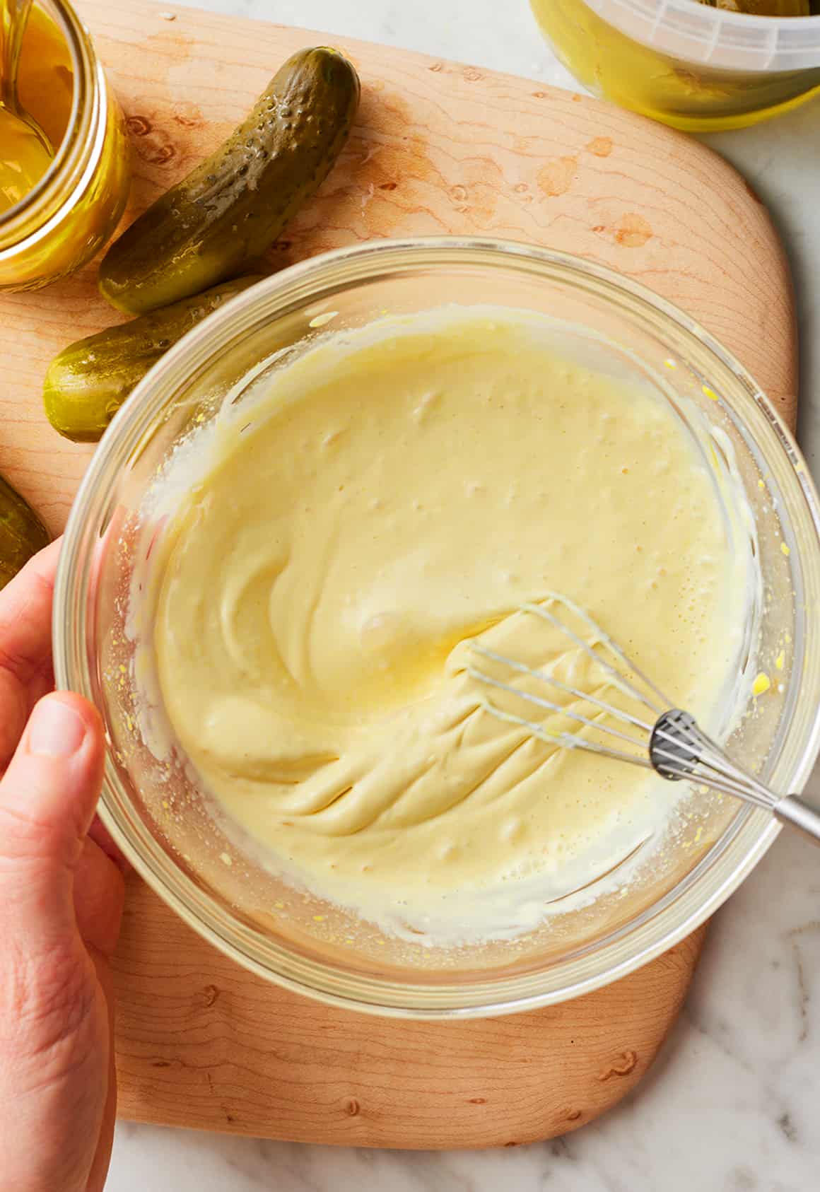 Whisking creamy dressing in glass bowl