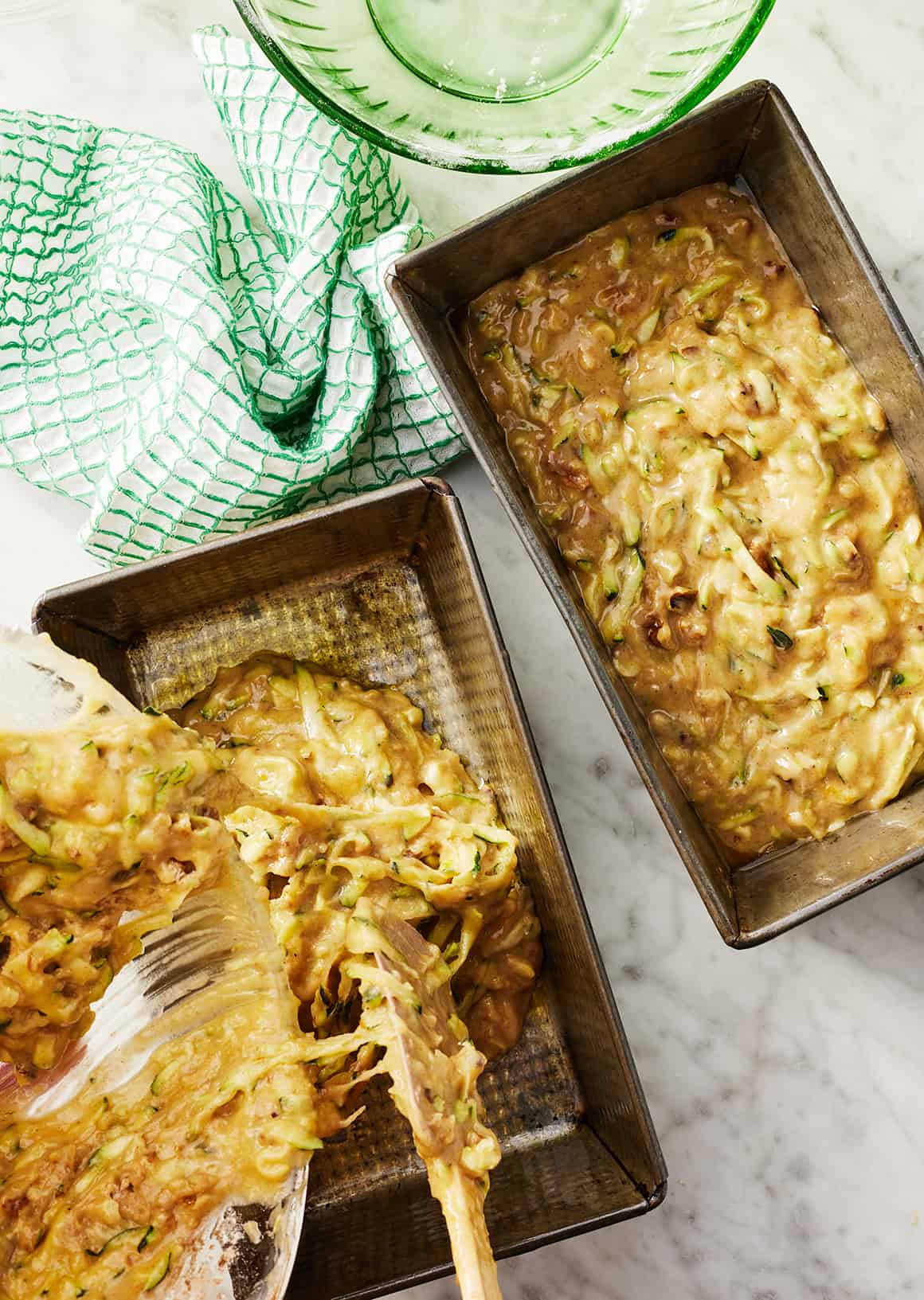 Pouring zucchini bread batter into loaf pans
