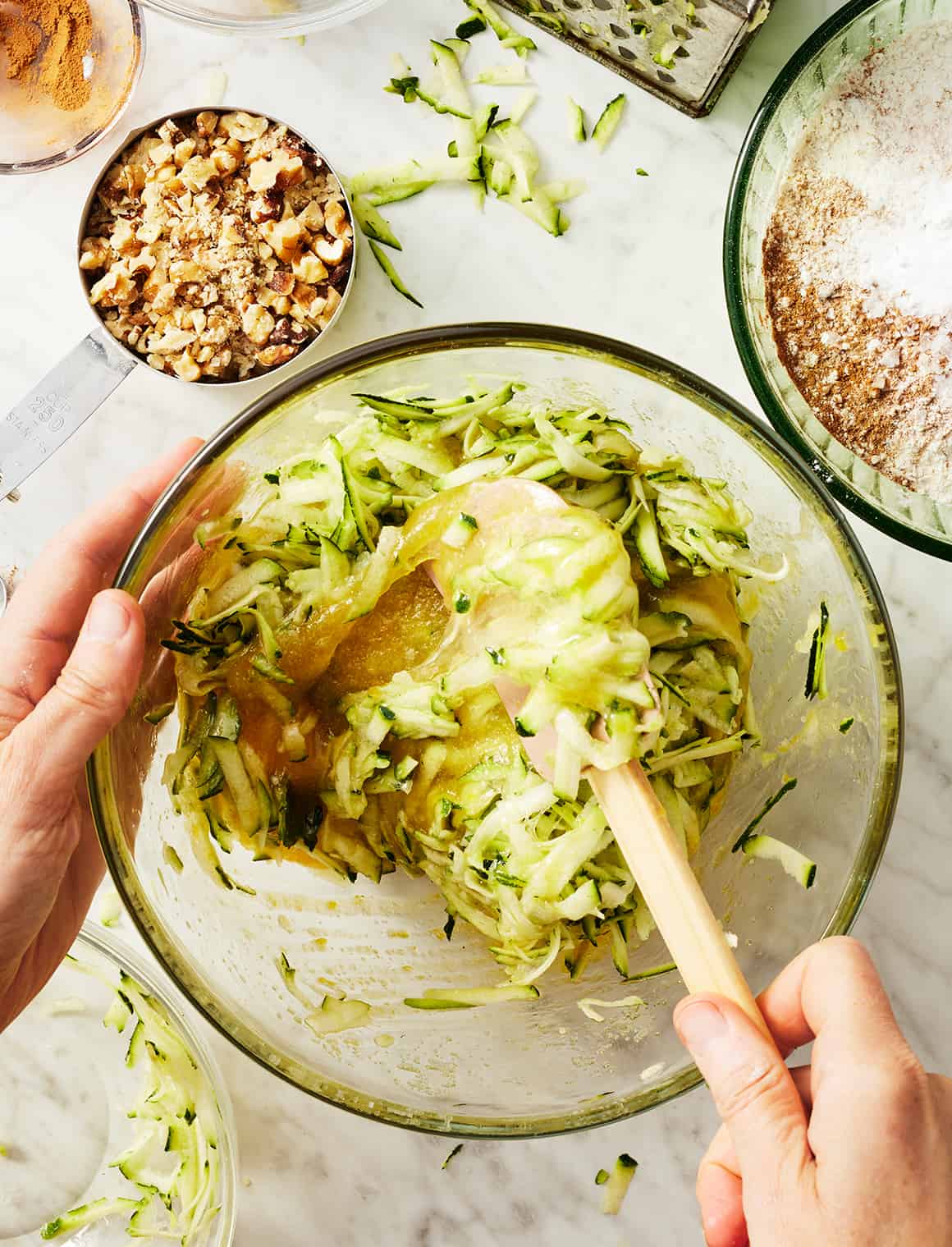 Mixing shredded zucchini into wet ingredients