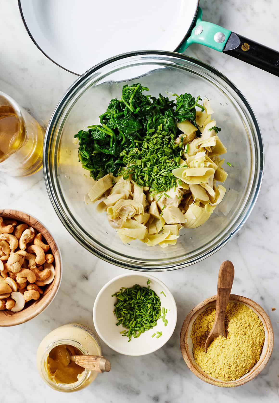 Spinach, chives, and artichokes in glass bowl