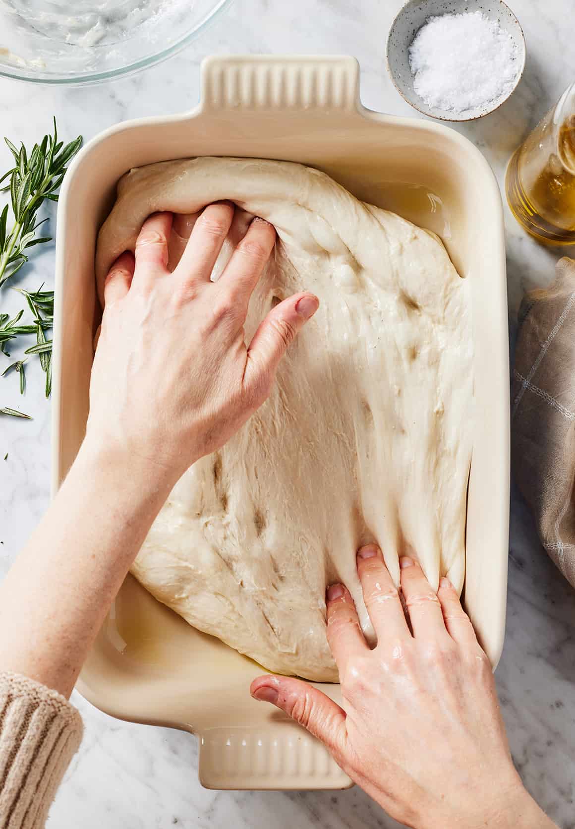 Pressing focaccia dough to edges of pan
