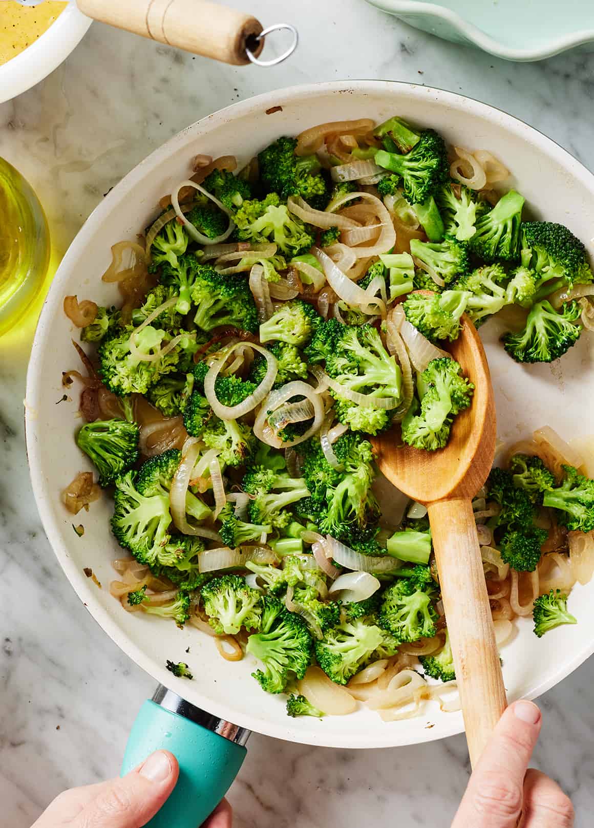 Sautéing broccoli and shallots in skillet