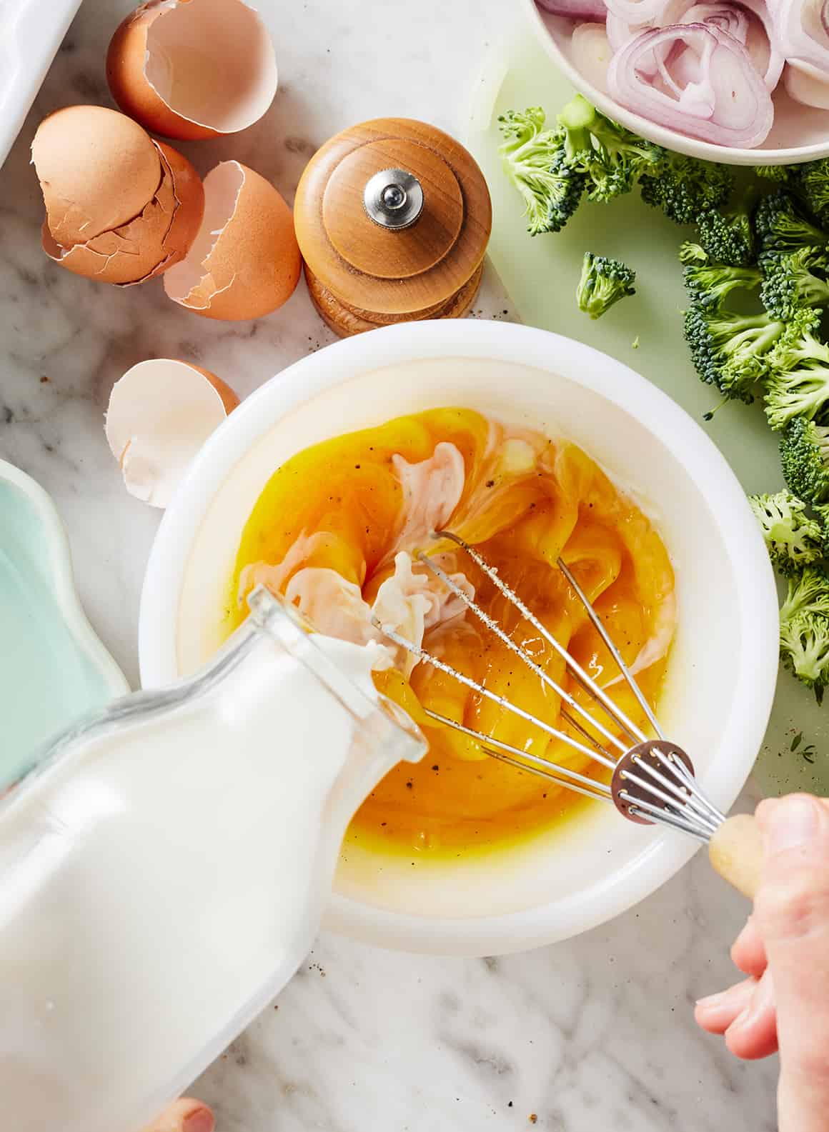Whisking eggs and milk in large bowl