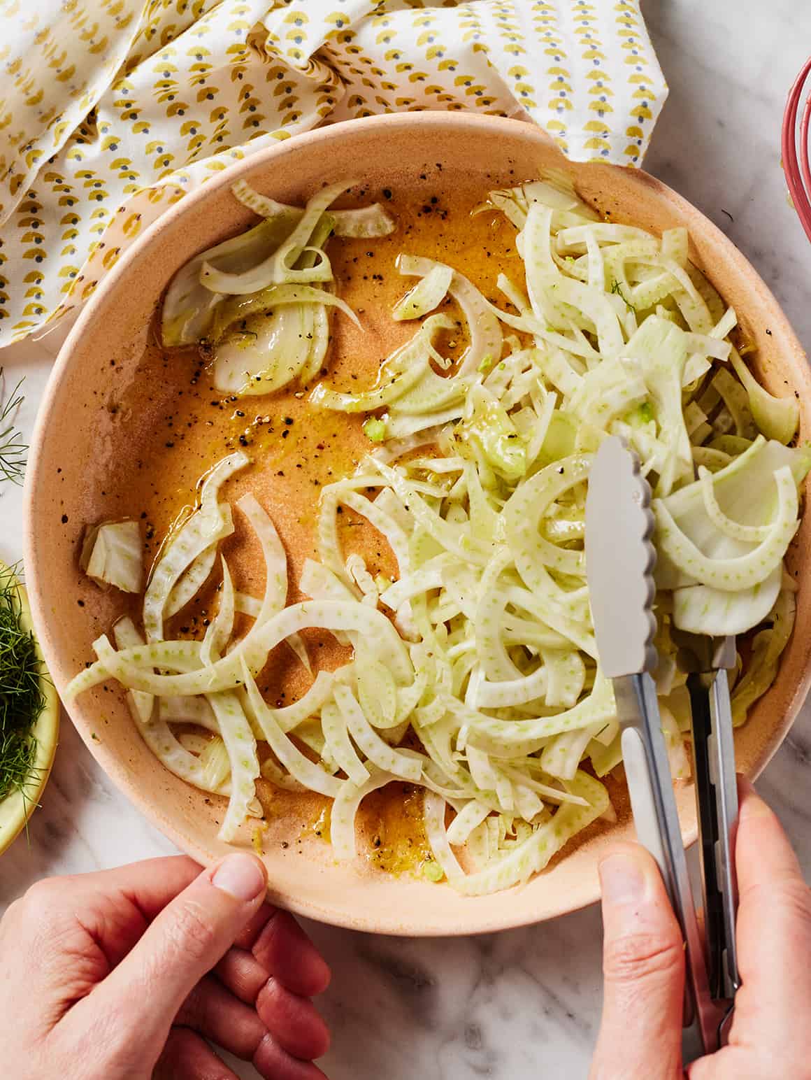 Tossing shaved fennel in dressing