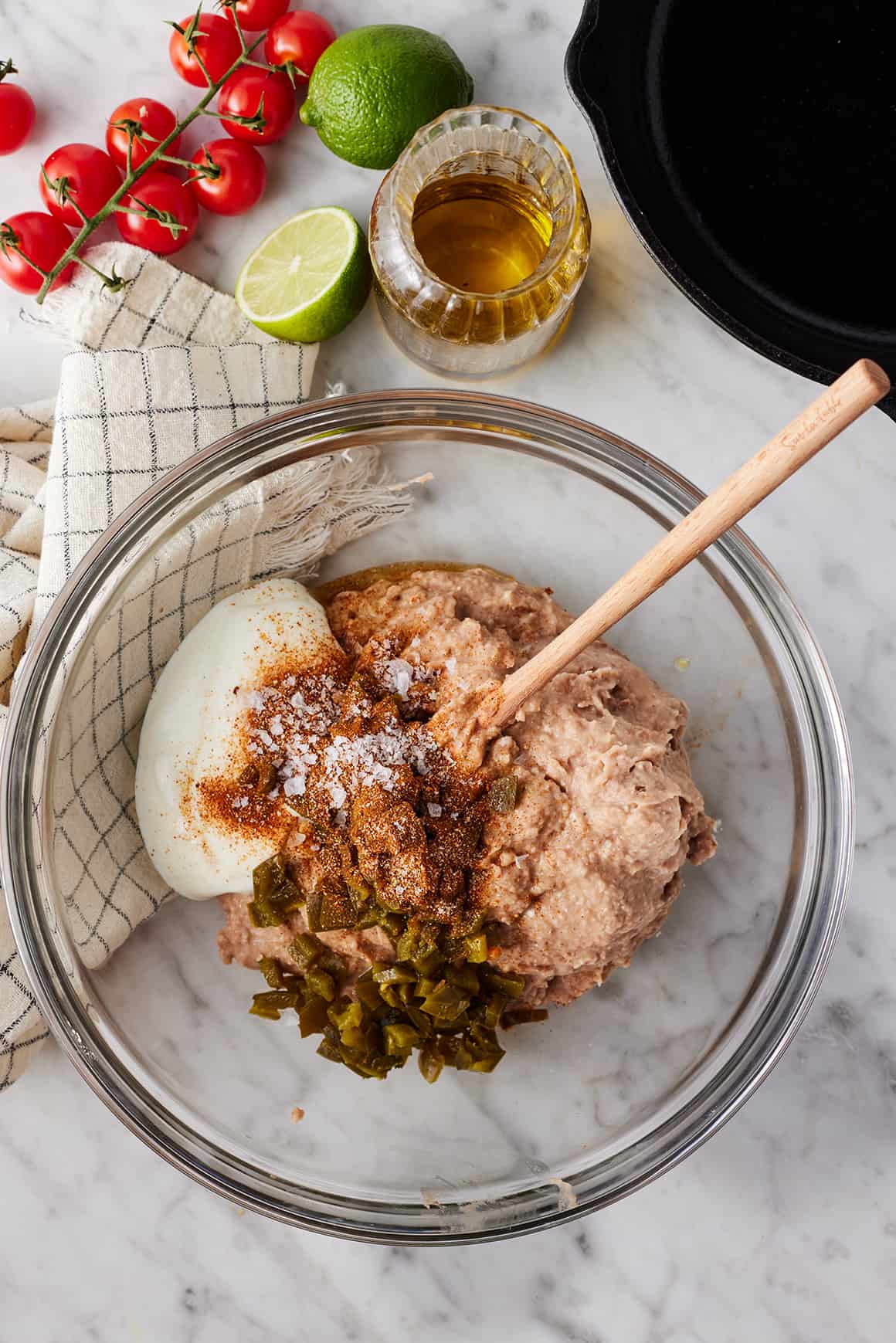 Refried beans, sour cream, green chiles, and spices in mixing bowl