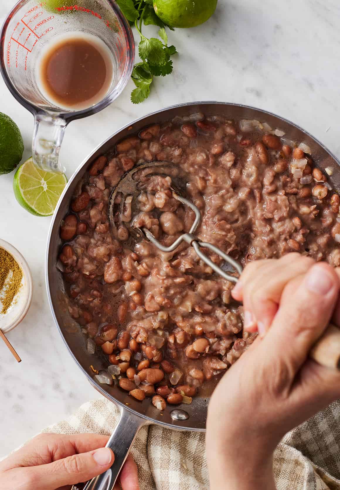 Mashing refried beans in skillet