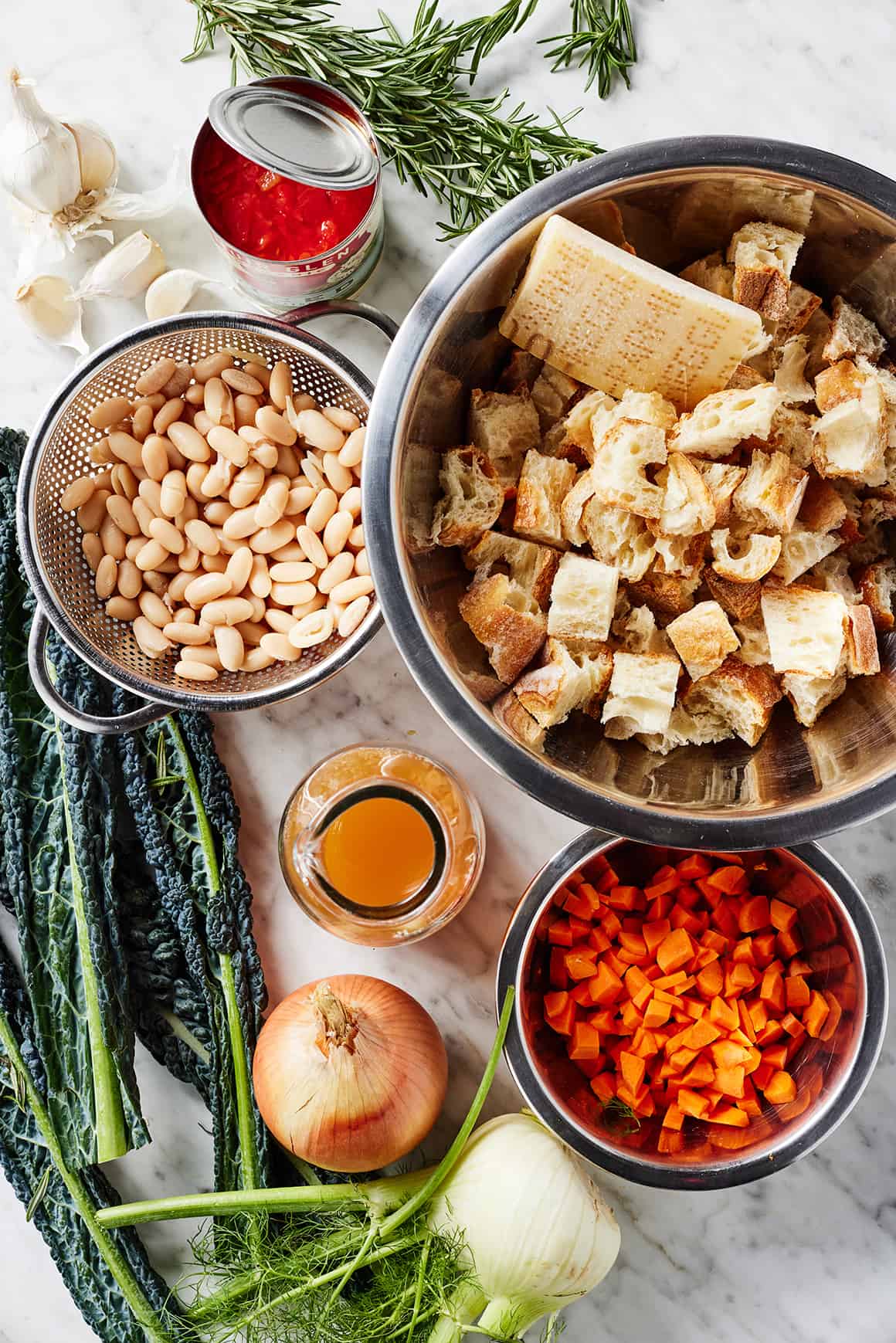 Ribollita recipe ingredients - stale bread, white beans, vegetables, broth, canned tomatoes, and herbs