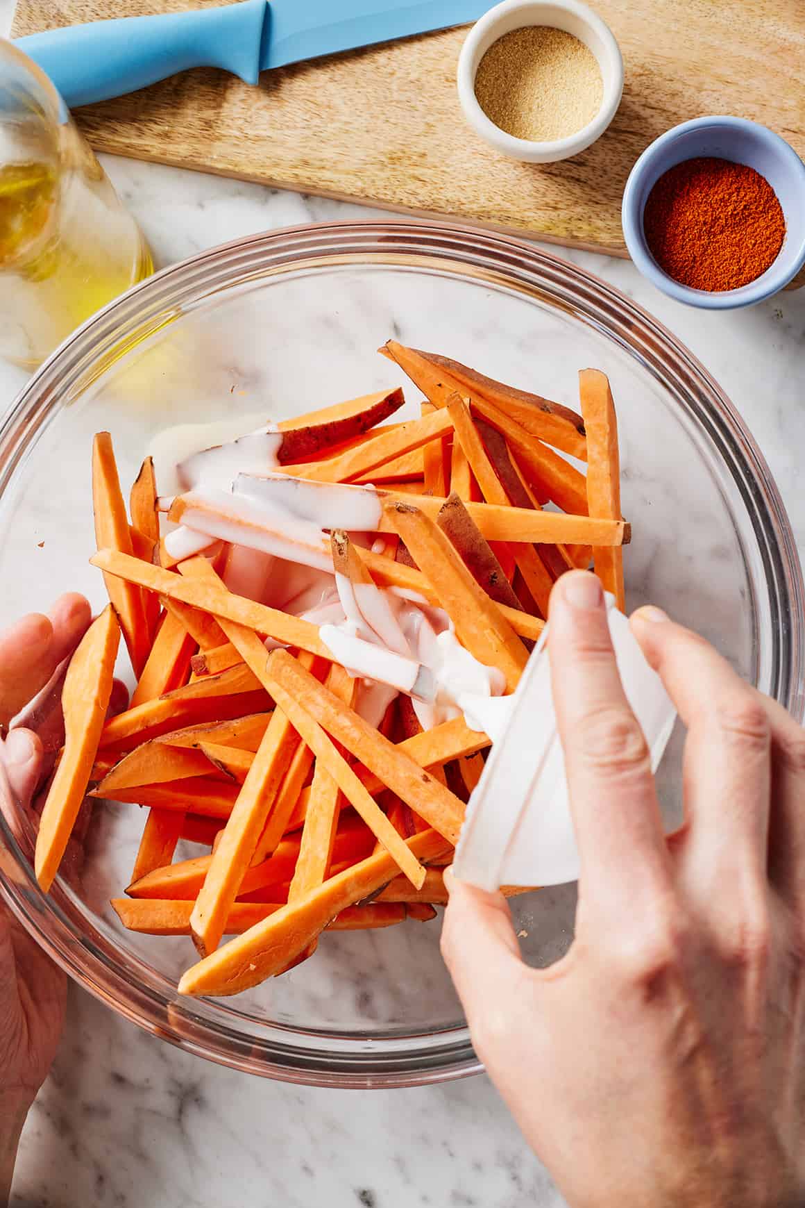 Pouring cornstarch slurry over sweet potato matchsticks