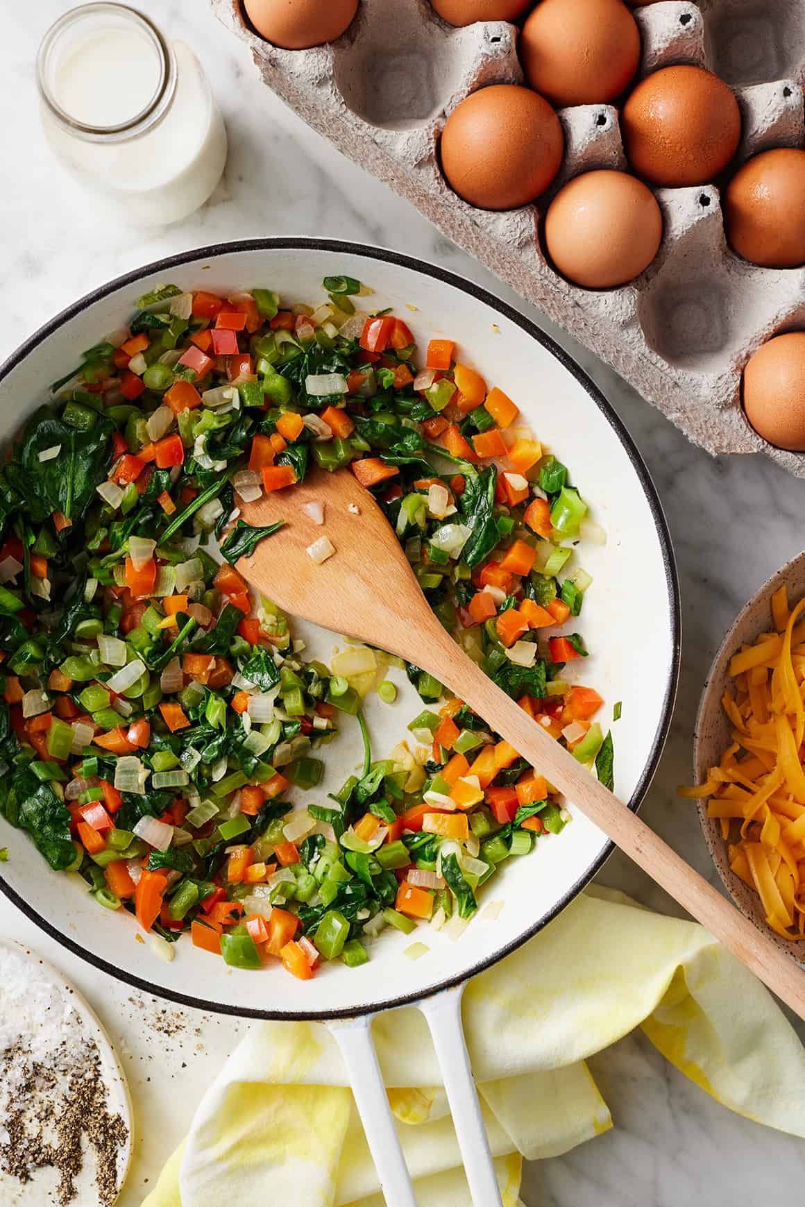 Sautéing vegetables in skillet with wooden spoon