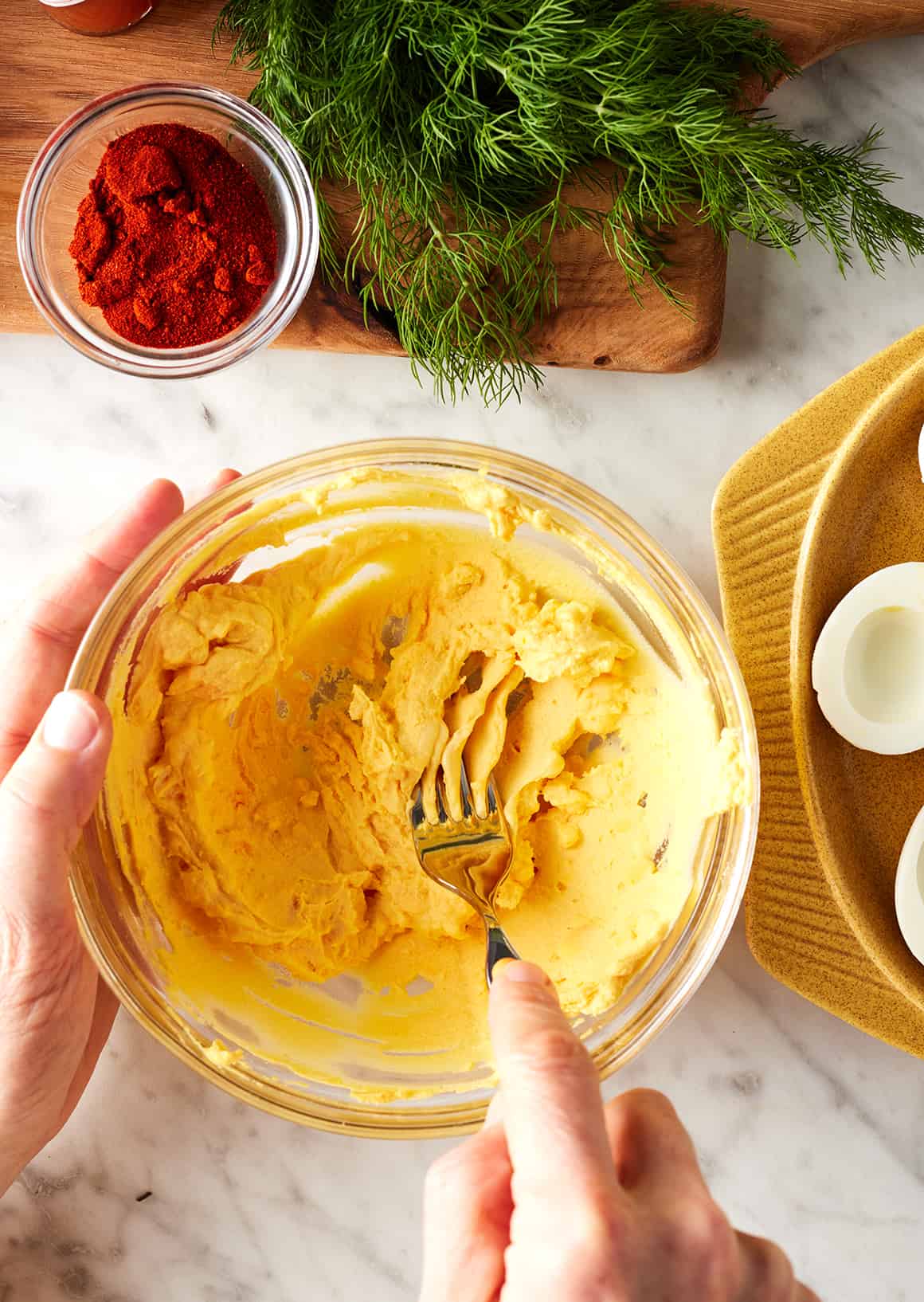 Mashing deviled eggs filling with fork