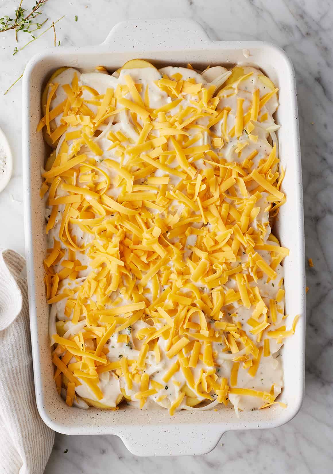 Scalloped potatoes (potatoes au gratin) assembled in baking dish
