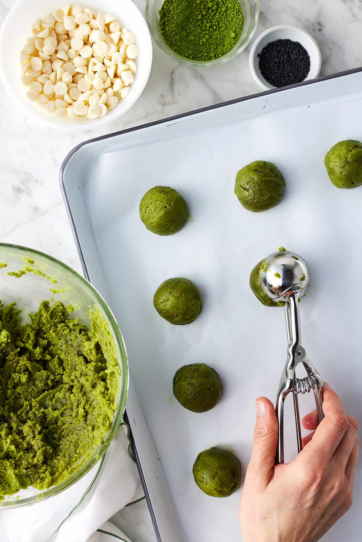 Scooping matcha cookies onto baking sheet