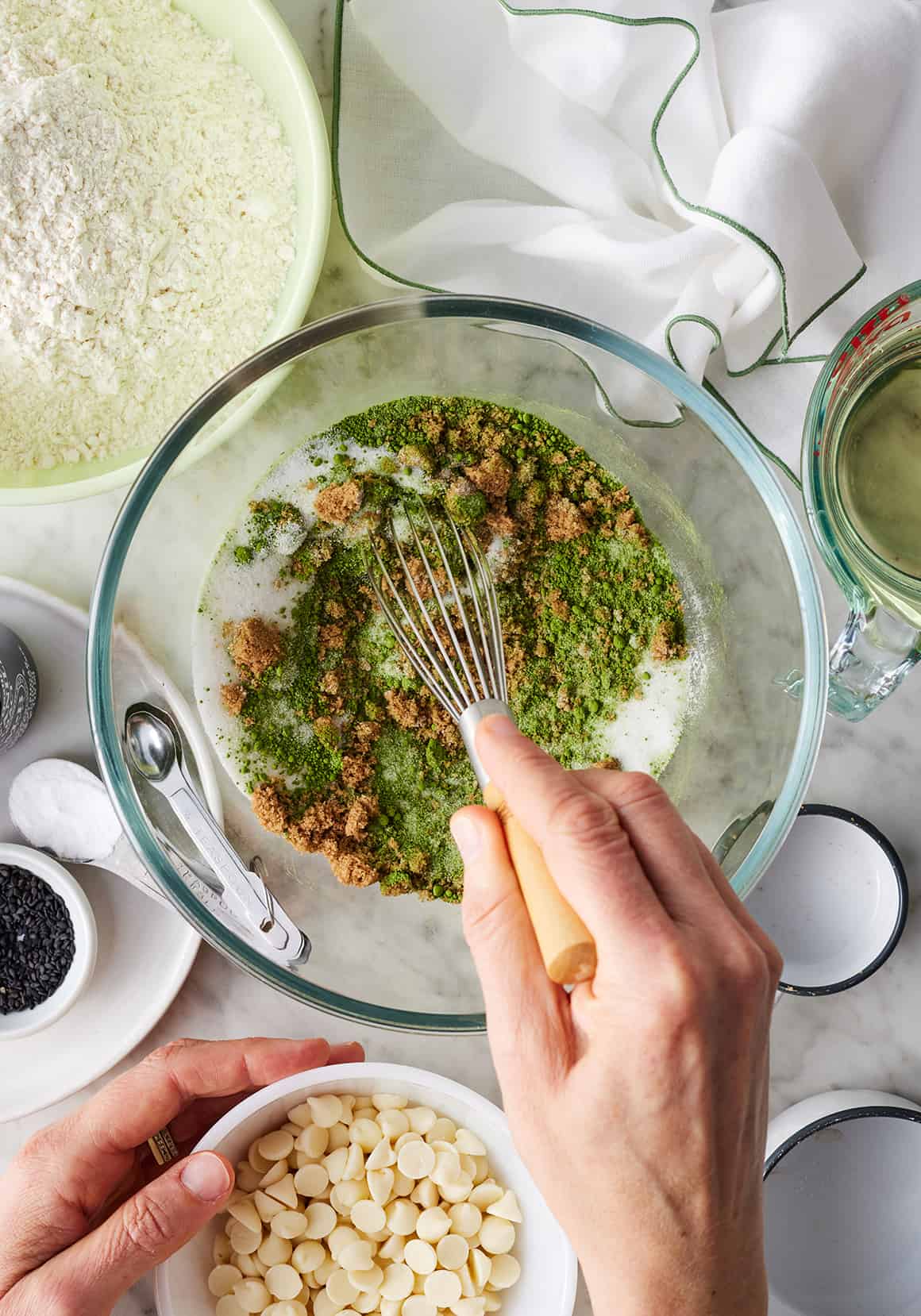 Whisking sugars and matcha powder in glass bowl