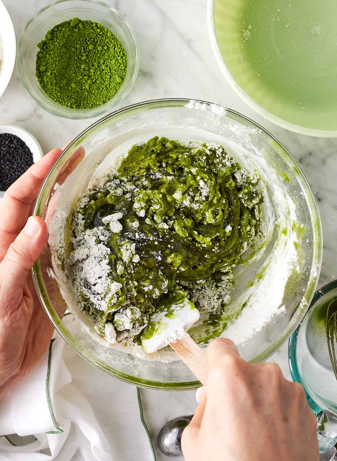 Mixing wet and dry ingredients with spatula in glass bowl