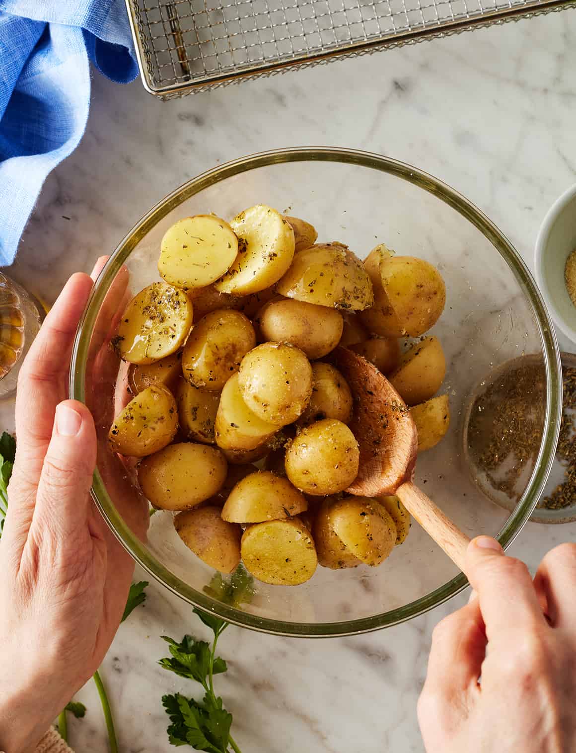 Tossing baby potatoes with oil and seasonings